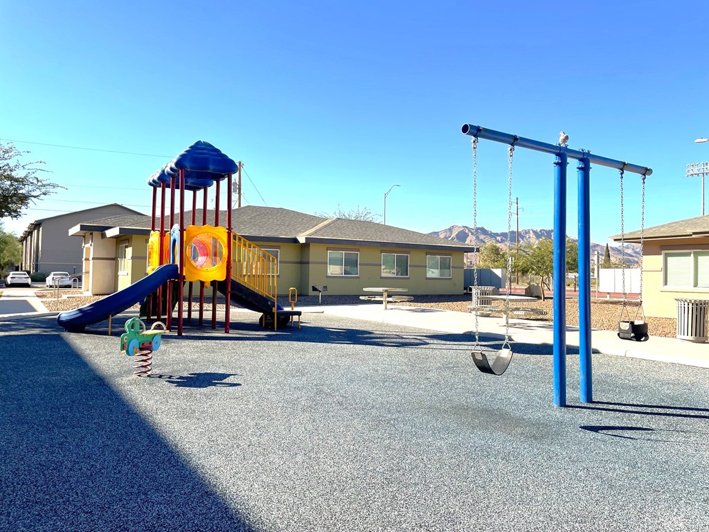 A playground with a blue swing set and a yellow slide.