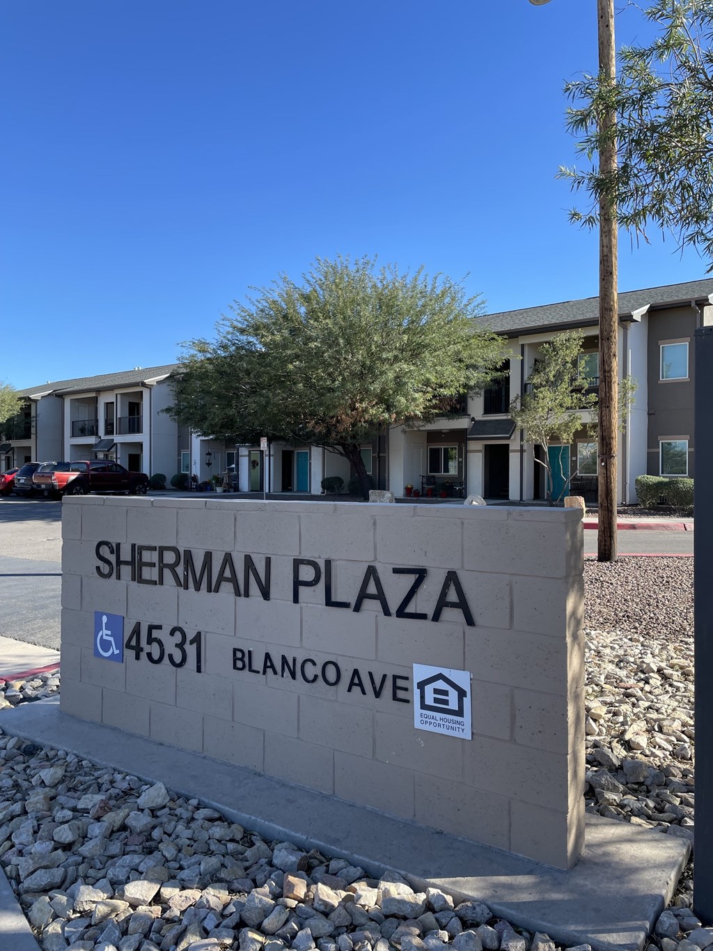 A sign for Sherman Plaza stands in front of a building.