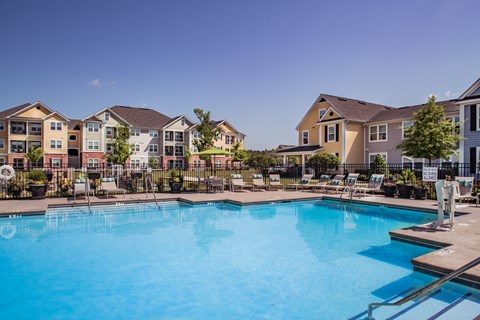 A large swimming pool in front of apartment buildings.