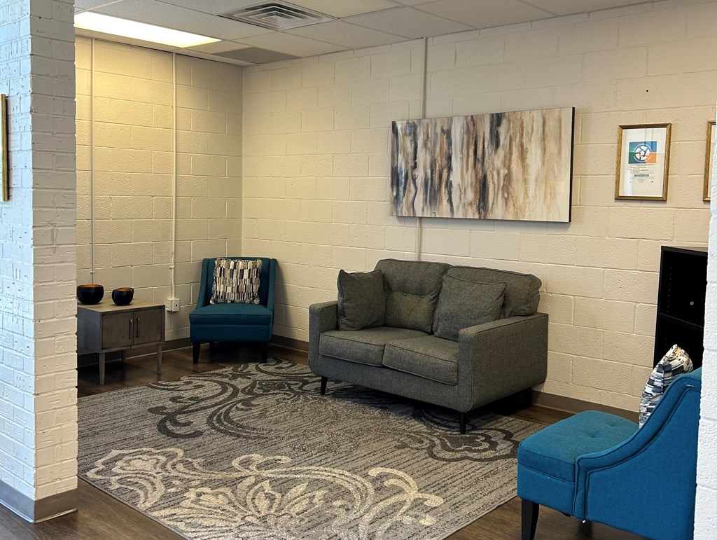 A living room with a grey couch and a blue chair.