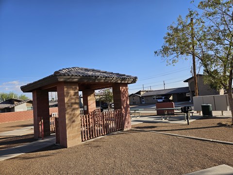 A gazebo-like structure sits in the middle of a playground.