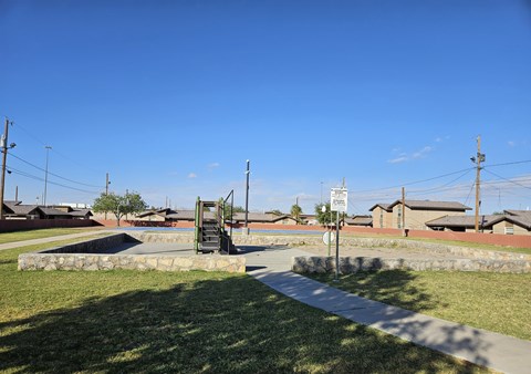 A sign is on a pole in the middle of a grassy area.