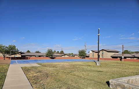 A clear blue sky over a residential area with houses and a utility pole.