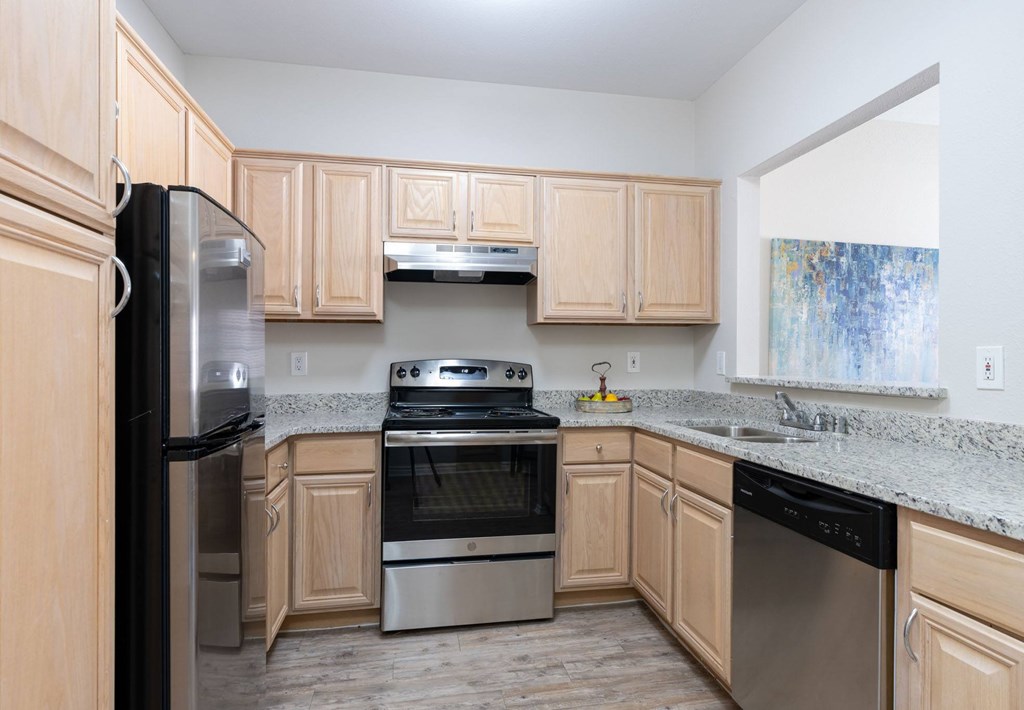 A kitchen with wooden cabinets and stainless steel appliances.