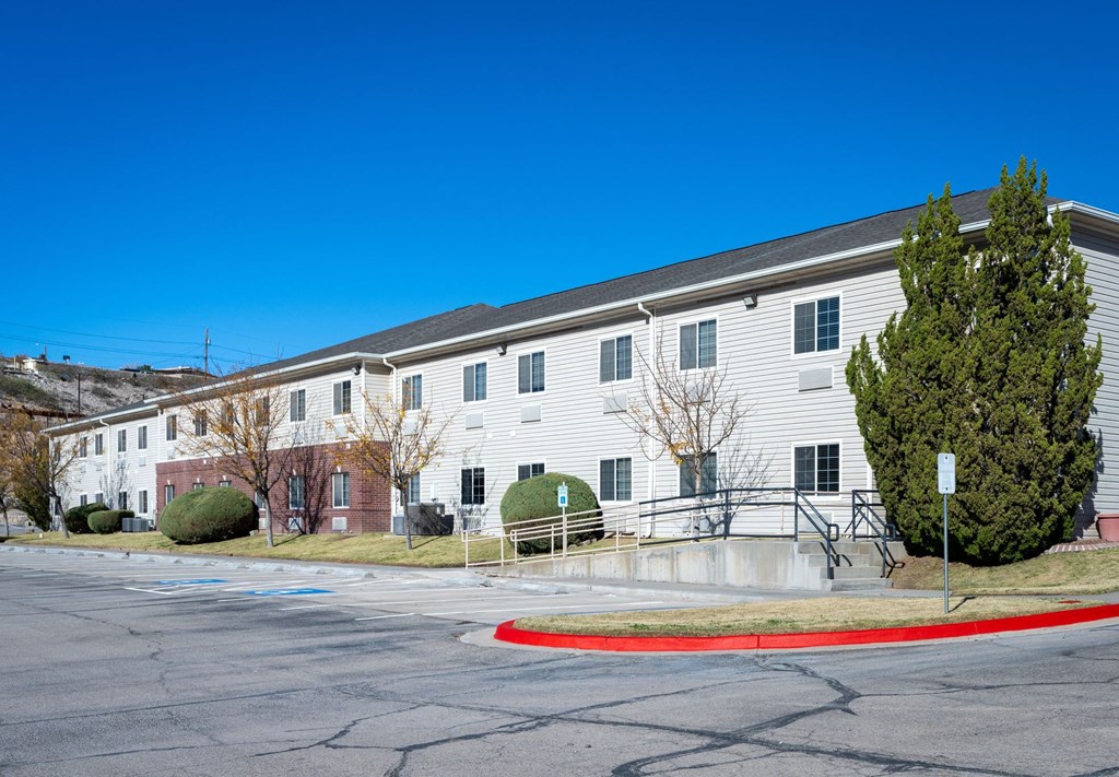 A large white building with a red curb in front of it.
