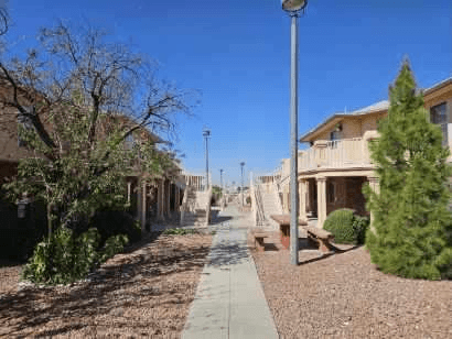 A street with a sidewalk and a tree in front of a house.