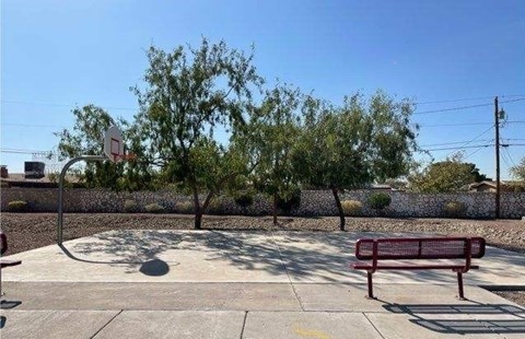 A basketball court with a red bench and a basketball hoop.