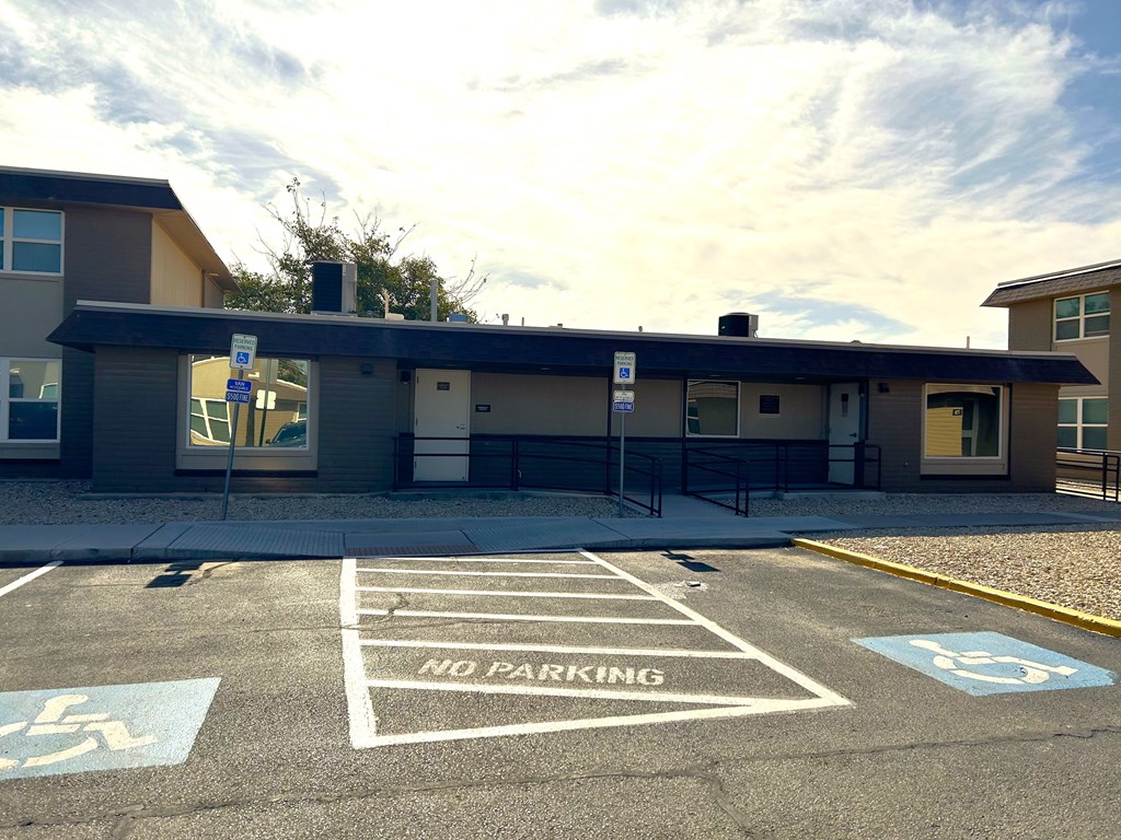 A parking lot with a building in the background and a sign that says "NO PARKING".