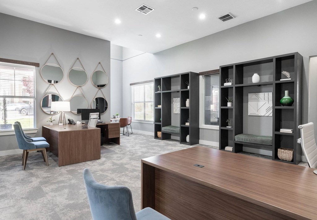 A modern office with a wooden desk and blue chairs.