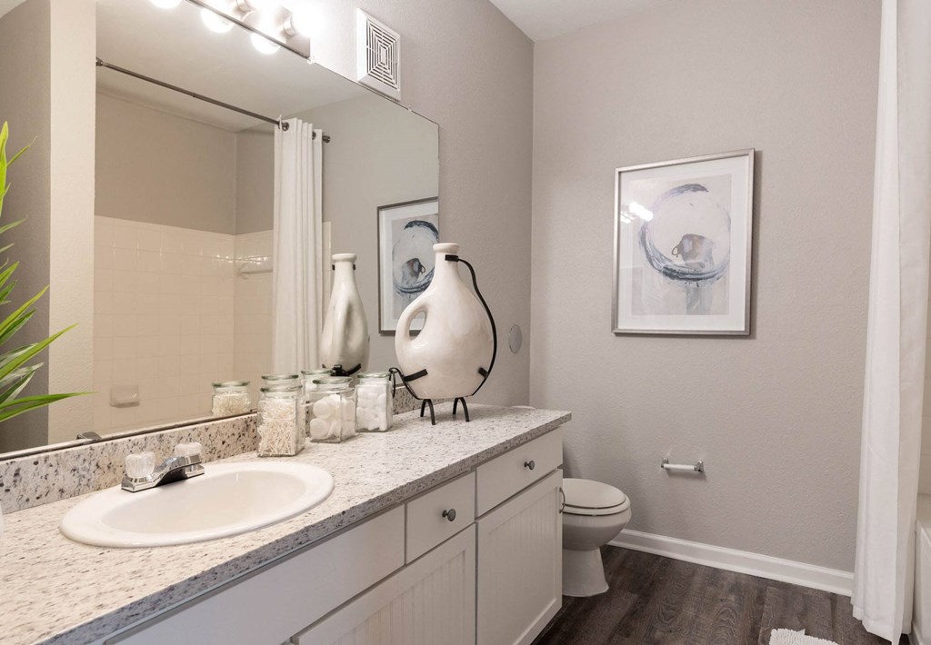 A bathroom with a white sink and a white toilet.