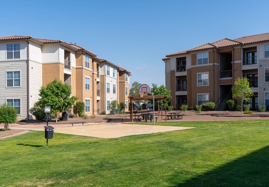 Apartment complex with a basketball court in front.