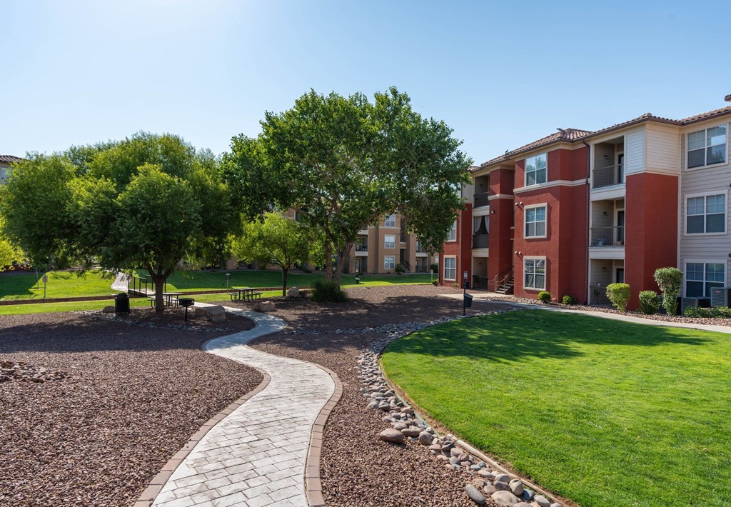 A residential area with apartment buildings and a gravel path.