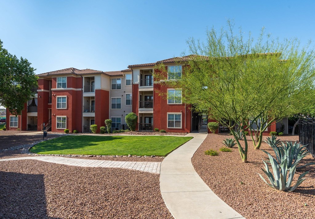 Apartment complex with a red brick building and a sidewalk.