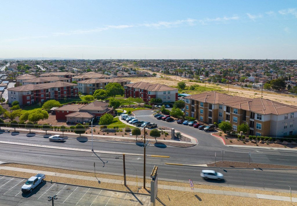 A view of a city from a high vantage point with buildings, cars, and a clear sky.