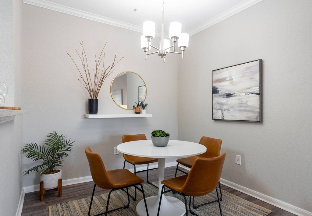 A dining room with a white table and chairs.