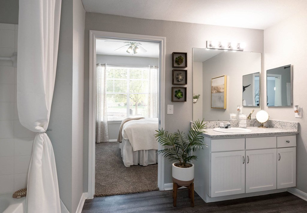 A bathroom with a white bed and a white sink.