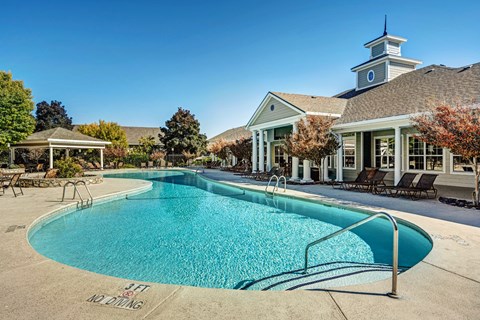 A pool with a building in the background.