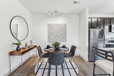 A modern dining room with a wooden table and chairs.