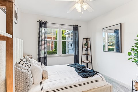 A bedroom with a large bed and a ceiling fan.