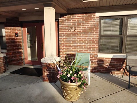 a planter with flowers in front of a brick building