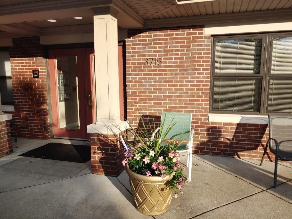 a planter with flowers in front of a brick building