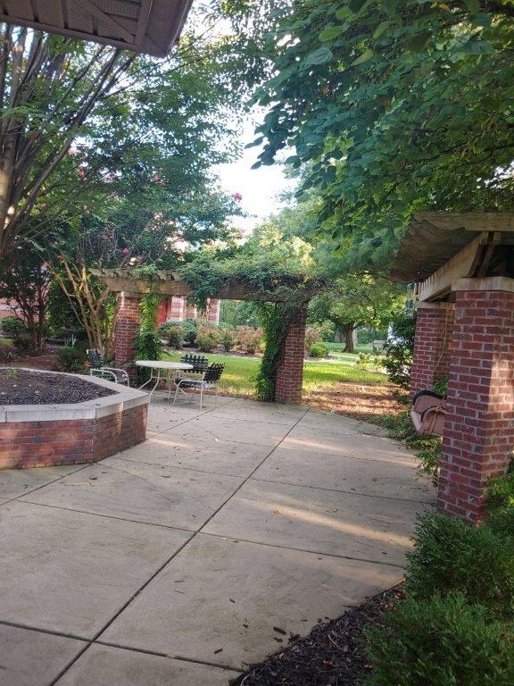 a patio with a brick building and trees