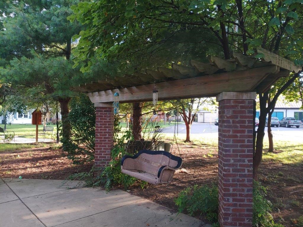 a bench sitting under a brick pavilion