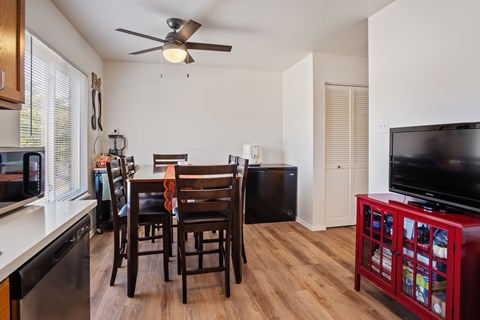 A kitchen with a dining table and chairs.