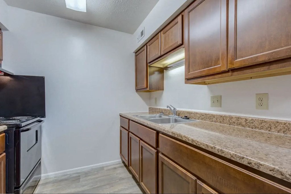 a kitchen with wooden cabinets and a black stove top oven