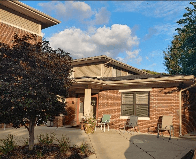 a brick house with a patio and chairs