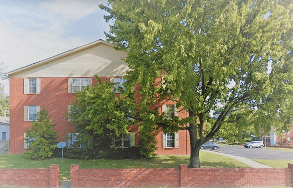 a red brick house with a tree in front of it