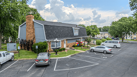 a house in a parking lot with cars in the parking lot