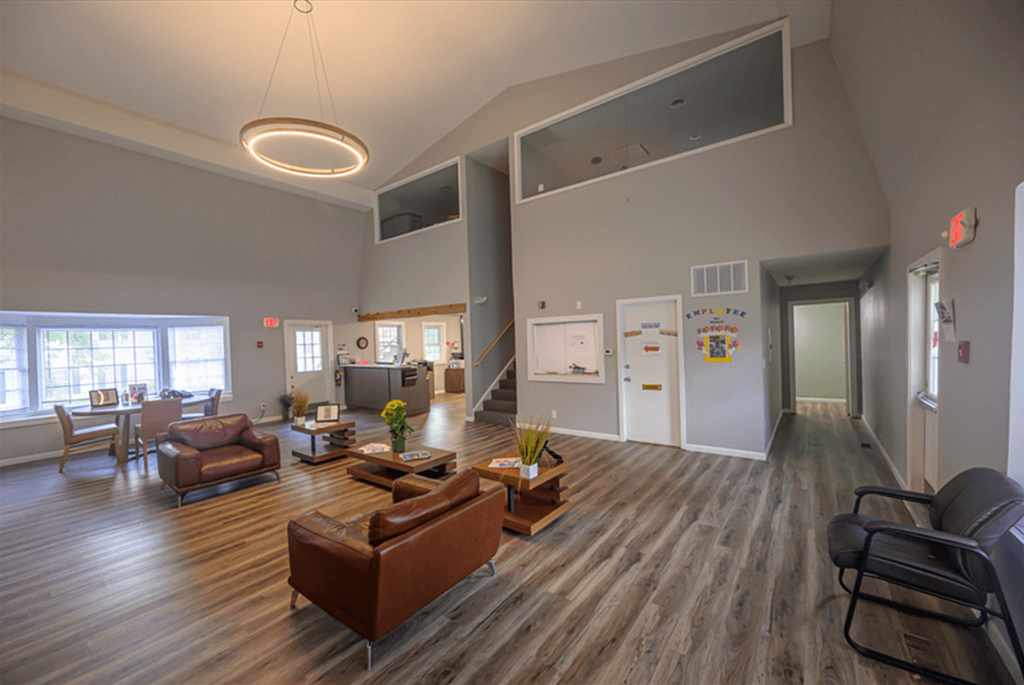 an open living room with couches and chairs and a kitchen