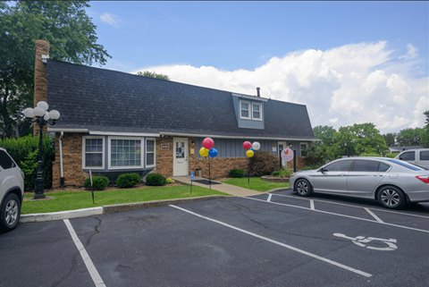 a house with balloons on the lawn and a parking lot