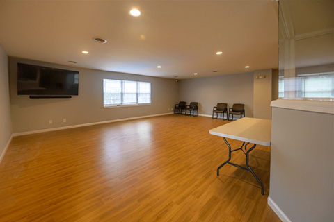 an empty living room with wood floors and a television