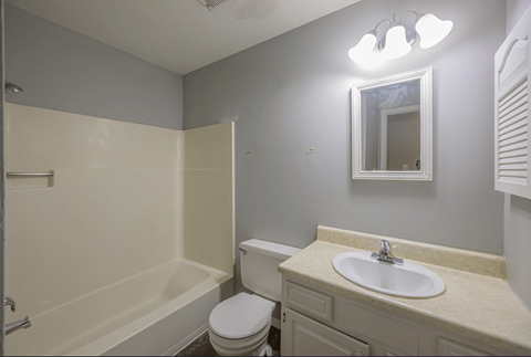 Apartment bathroom with bathtub, toilet, and vanity