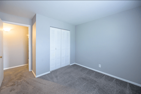 an empty room with a door to a closet