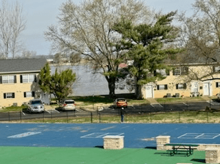 a tennis court with cars parked in front of houses