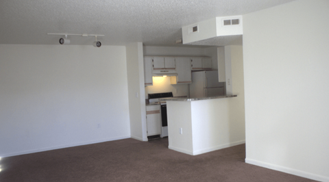 A white kitchen with a white cabinet and a white fridge.