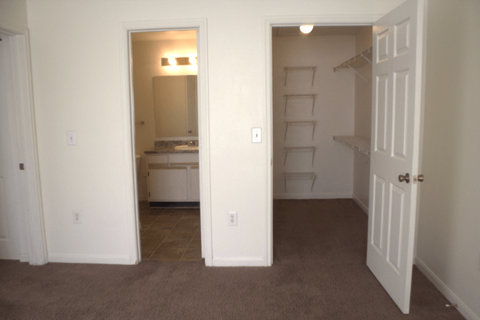 a bedroom with a closet and a door open to a bathroom
