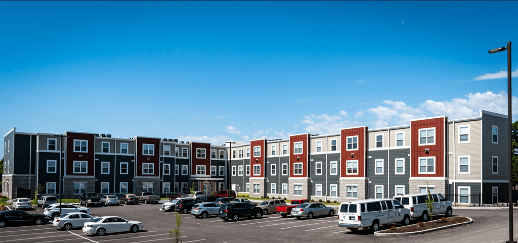 a rendering of an apartment building in a parking lot with cars