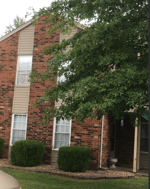 a brick house with a tree in front of it