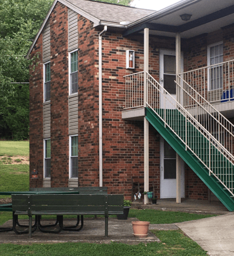 a bench in front of a building with stairs
