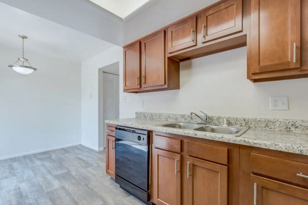 a kitchen with wood cabinets and a black dishwasher
