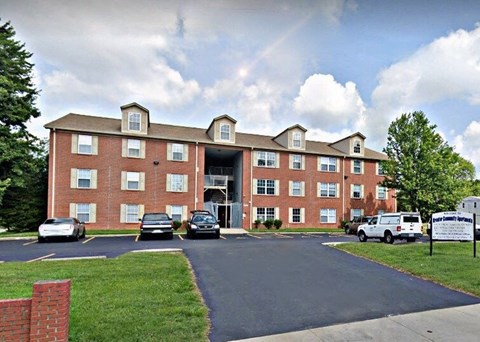 a large brick building with cars parked in front of it