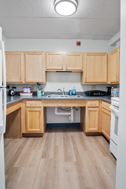 A kitchen with wooden cabinets and a white refrigerator.