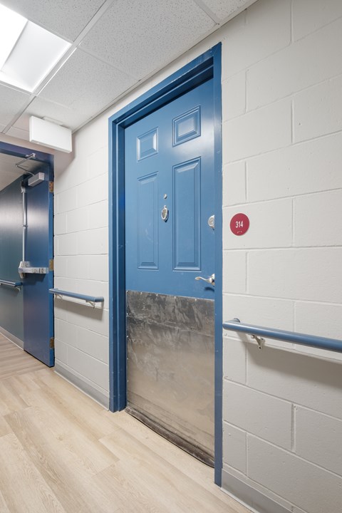 A blue door with a red sign on the wall.