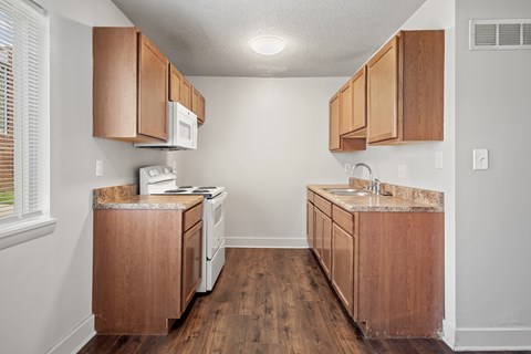 A kitchen with wooden cabinets and a white microwave.