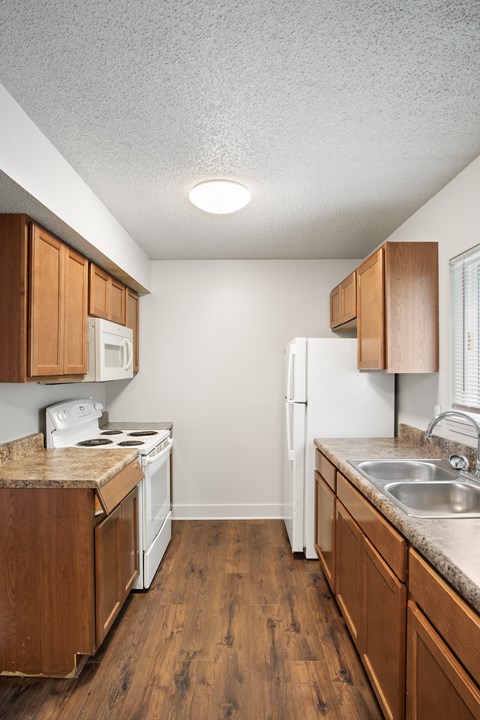 A kitchen with white appliances and wooden cabinets.