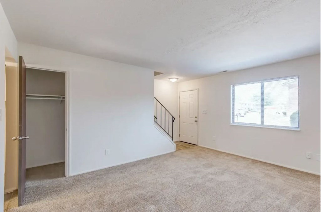 a bedroom with white walls and a large window